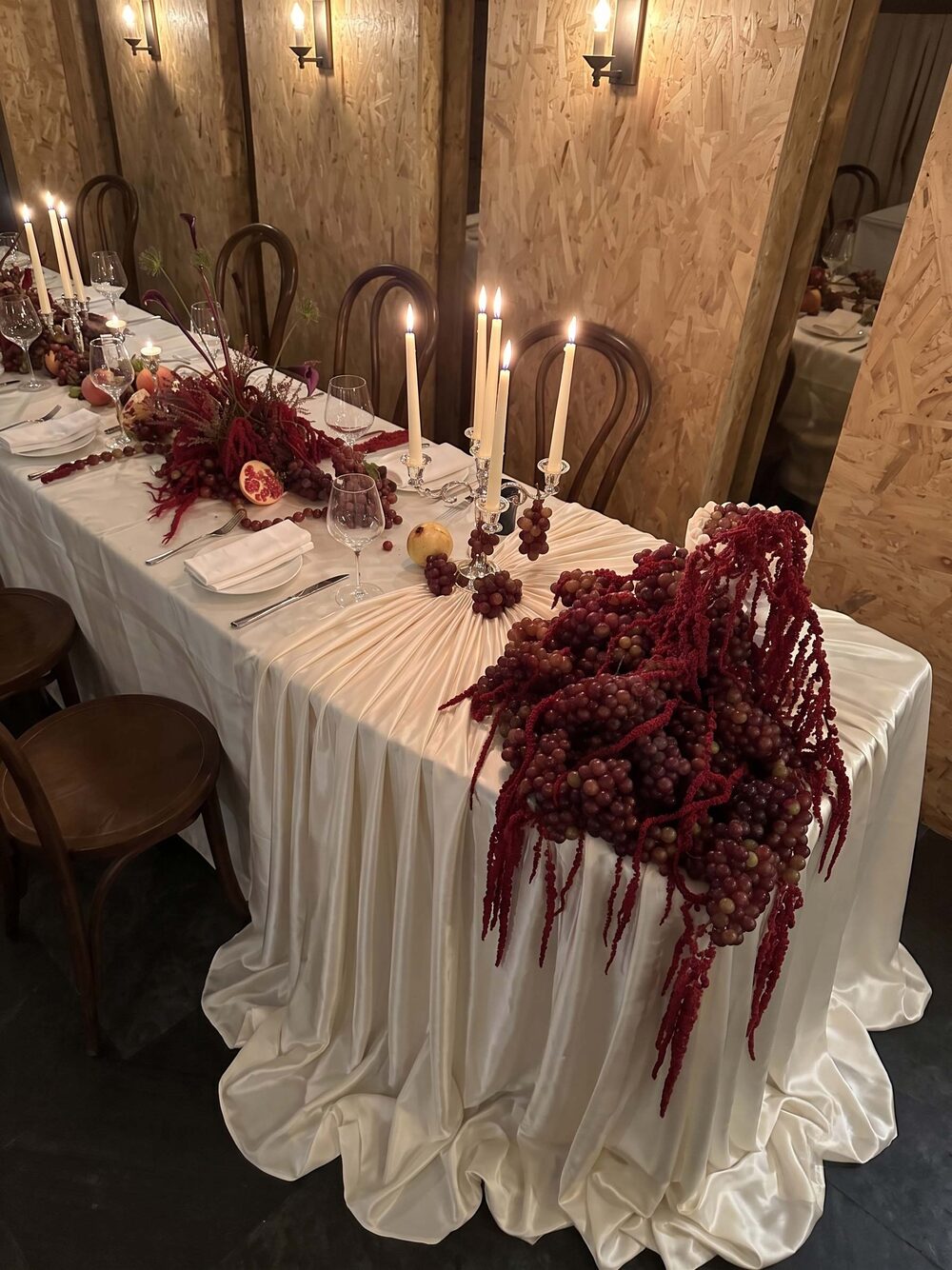 Long table with amaranth, grapes and taper candles